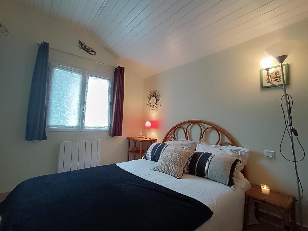 une chambre avec un lit avec des oreillers et une fenêtre dans l'établissement Maison Brévinoise, bien équipée, proche plage et commerces - 5 pers, 2 terrasses, parking - FR-1-364-90, à Saint-Brévin-les-Pins