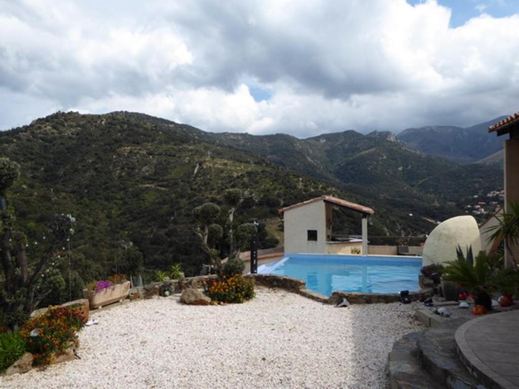 a house with a swimming pool with mountains in the background at Villa Sorède, 4 pièces, 6 personnes - FR-1-776-11 in Sorède