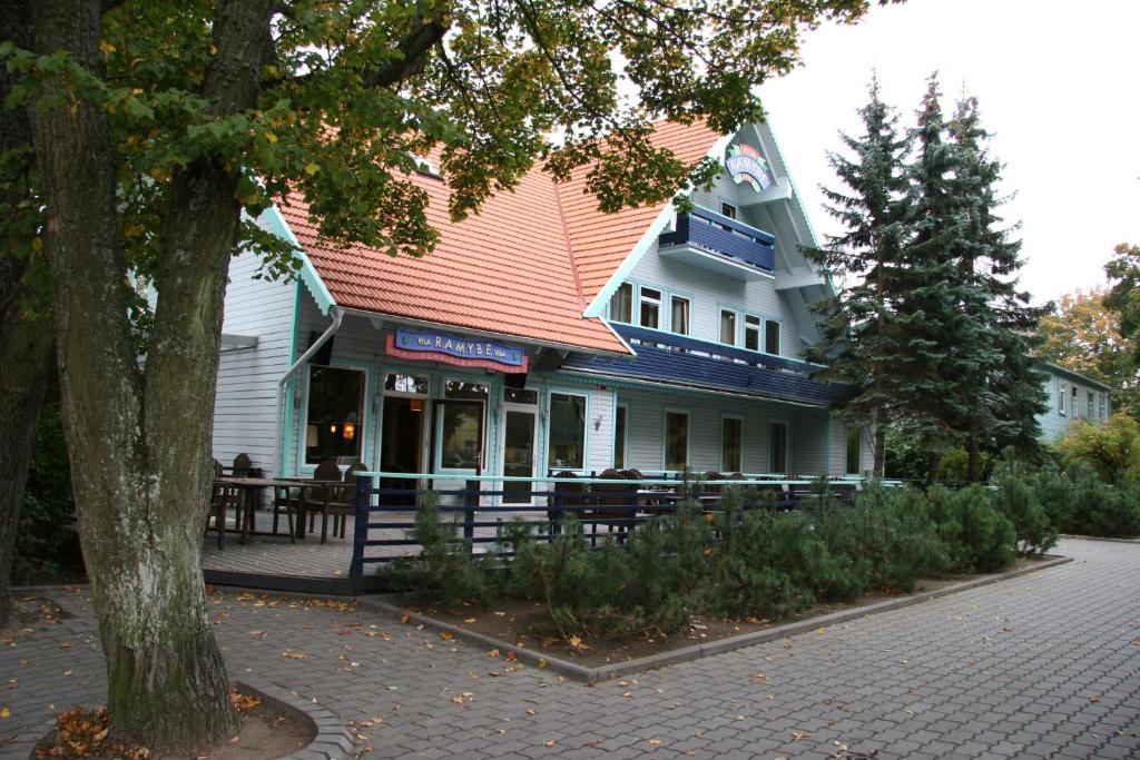 un edificio azul y blanco con techo rojo en Vila Ramybe, en Palanga