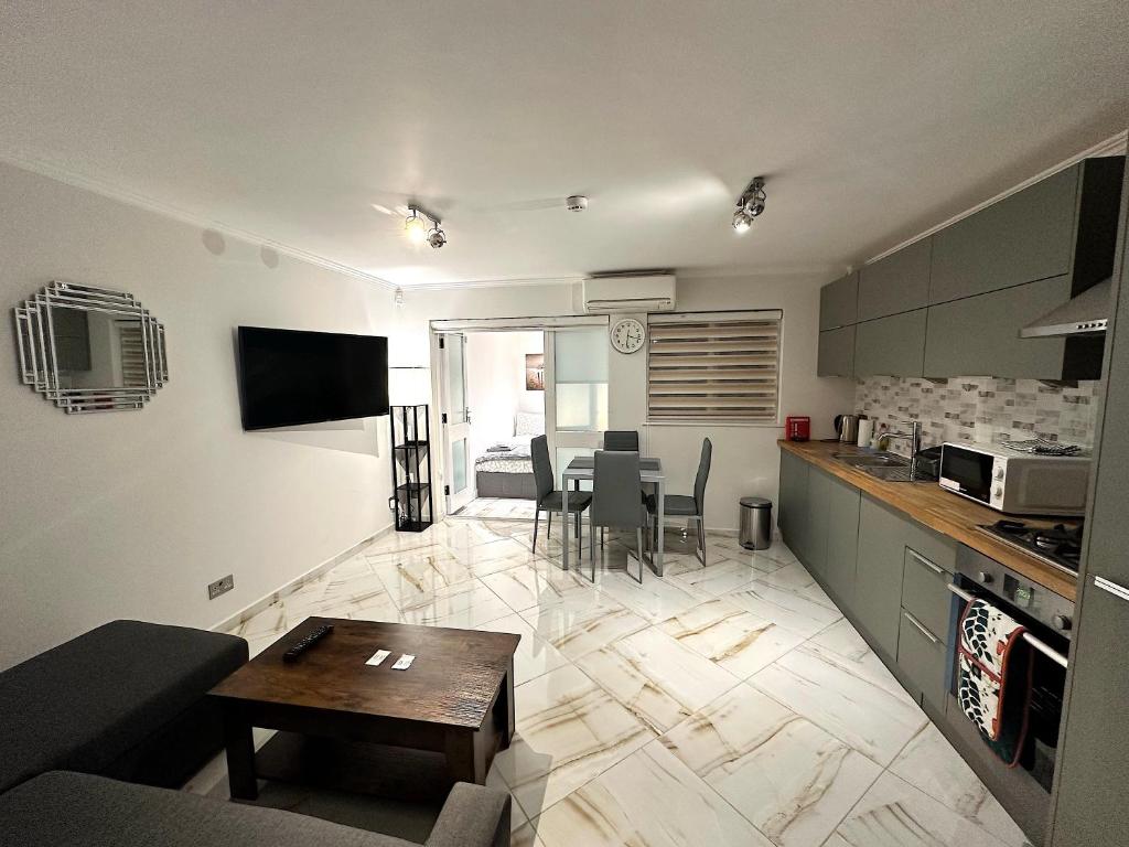 a kitchen and a living room with a table in a room at Central London Zone 1 apartment in London