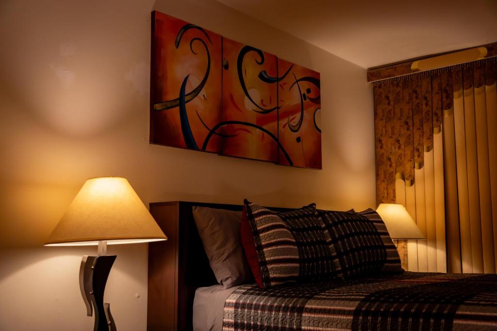 1 dormitorio con 1 cama y una pintura en la pared en Spacious Comfy Room in Cozy Classy Duplex en Brooklyn
