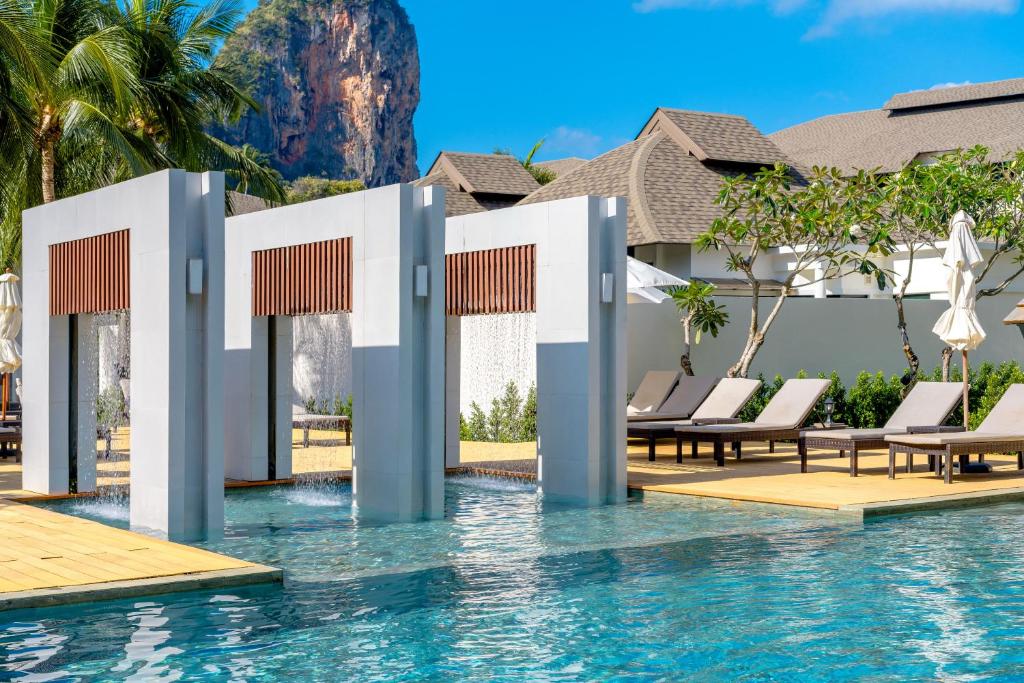 a pool at a resort with lounge chairs at Bhu Nga Thani Resort & Villas Railay in Railay Beach