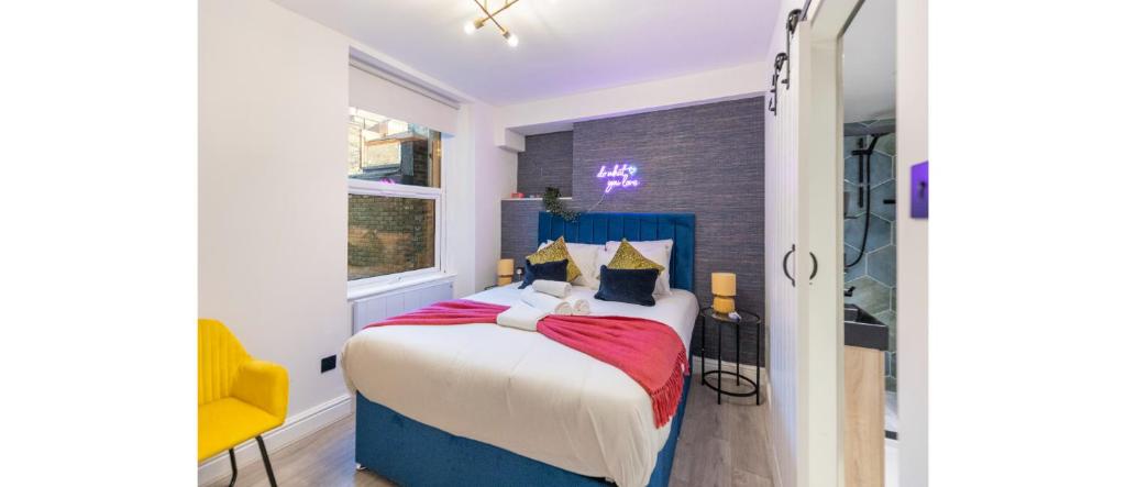 倫敦的住宿－Urban Spectrum: Vibrant Studio with Kitchenette，一间卧室配有一张床和一张黄色椅子