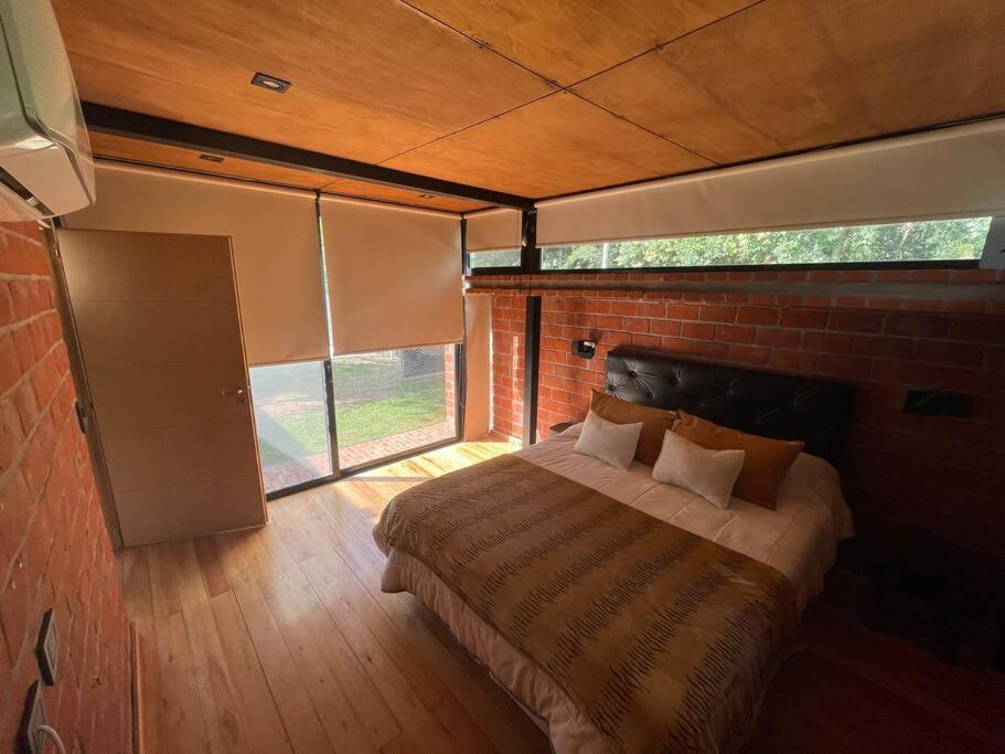 - une chambre avec un lit dans un mur en briques dans l'établissement La Retirada Hospedaje, à Arturo SeguÃ­