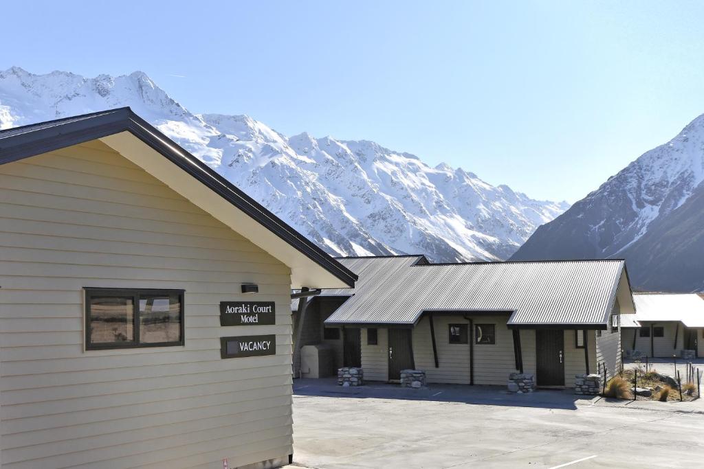 een gebouw met een bord voor een berg bij Aoraki Court Motel in Mount Cook Village