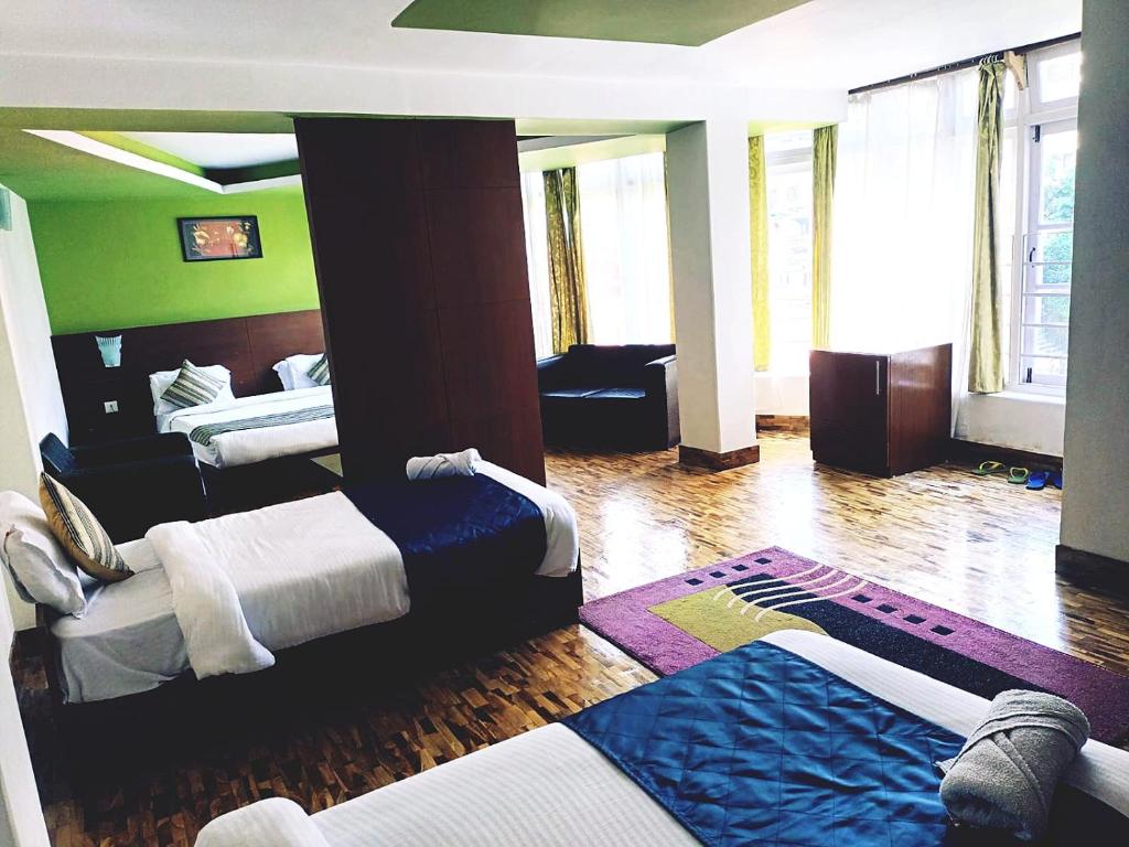 Habitación de hotel con 2 camas y sofá en Hotel Le Primula, en Gangtok