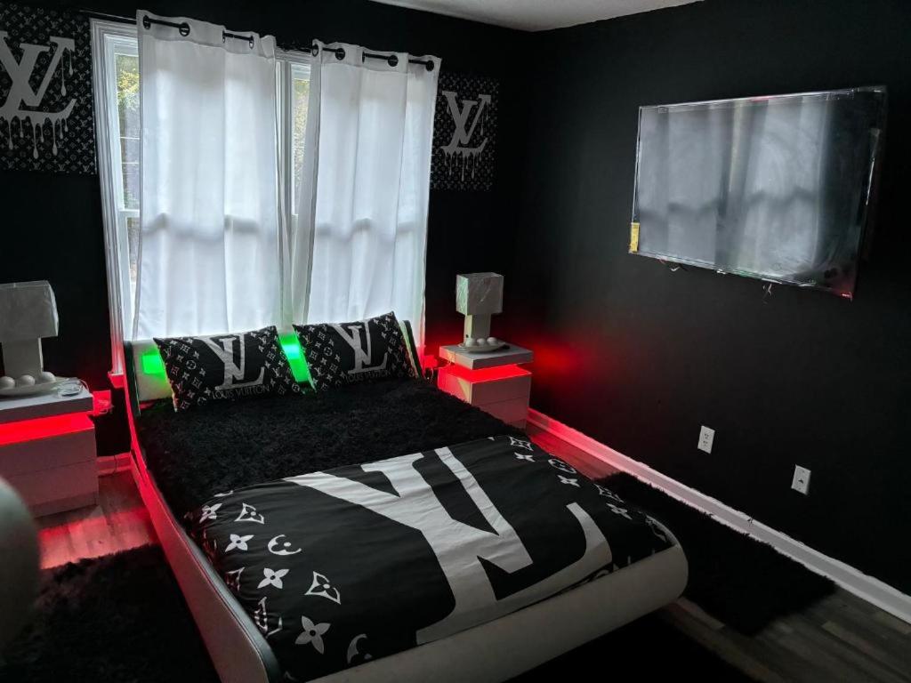 a black bedroom with a bed and a window at Pressure Pad in College Park