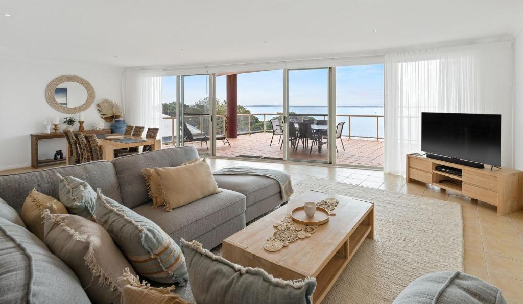 een woonkamer met een bank en een televisie bij Penthouse Esplanade Cowes - Beach Front - Sea View in Cowes