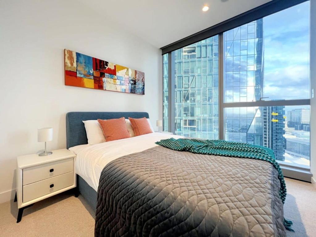 een slaapkamer met een bed en een groot raam bij Experience Melbourne in Styles in Melbourne