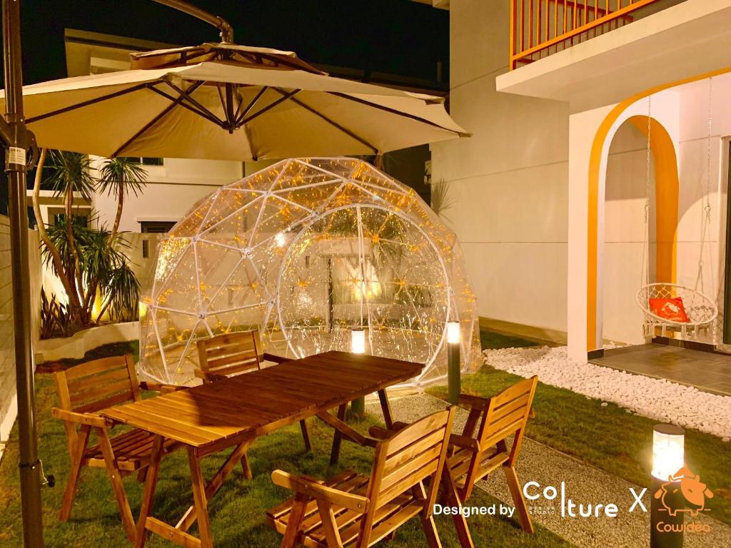 a wooden table and chairs and an igloo at 30-80 pax Private Event Venue - Sunset Paradise by Cowidea in Masai