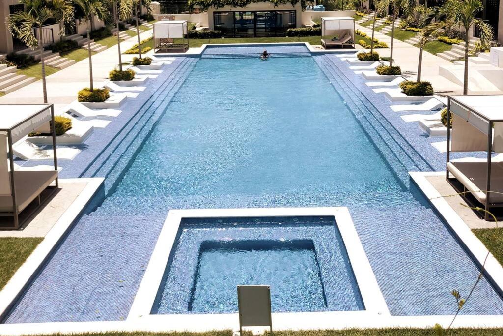 a swimming pool with blue water in a resort at Ensueño en Nuevo Vallarta in Nuevo Vallarta 