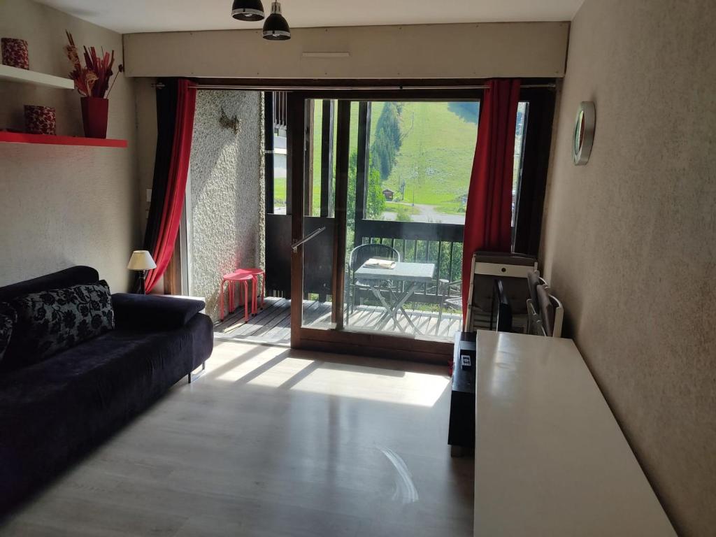 a living room with a couch and a sliding glass door at Appartement Les Gets, 1 pièce, 4 personnes - FR-1-671-257 in Les Gets