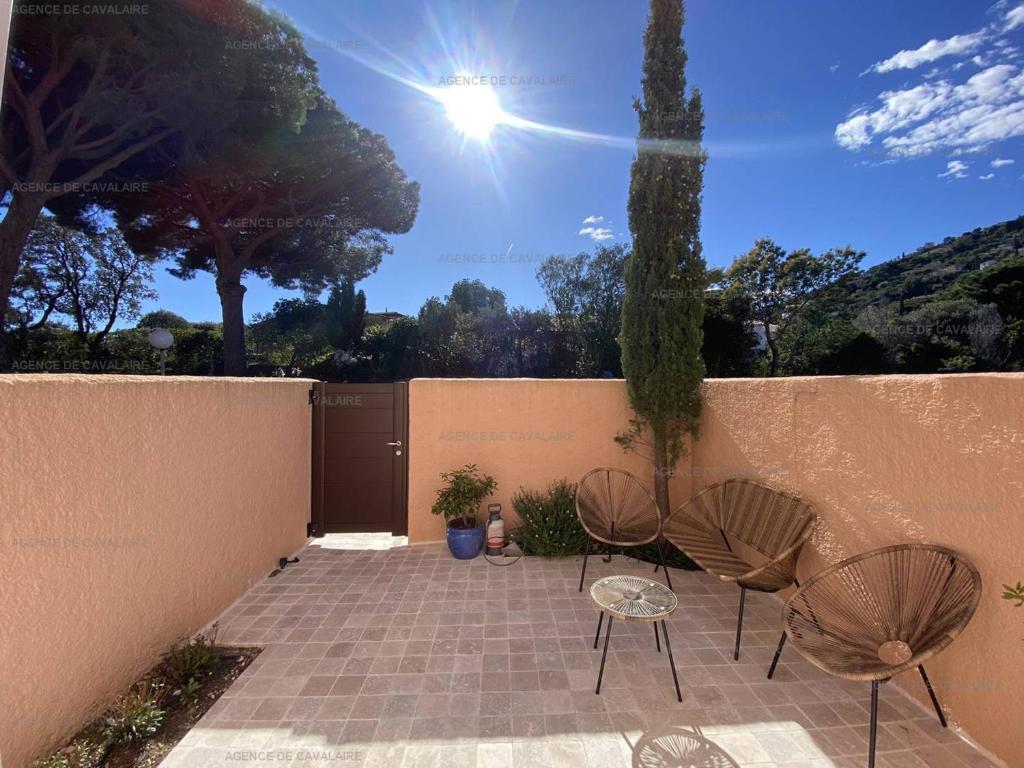 une terrasse avec 2 chaises et une clôture dans l'établissement Mazet rénové avec piscine, tennis, 2 terrasses à Cavalaire-sur-Mer. - FR-1-100-333, à Cavalaire-sur-Mer