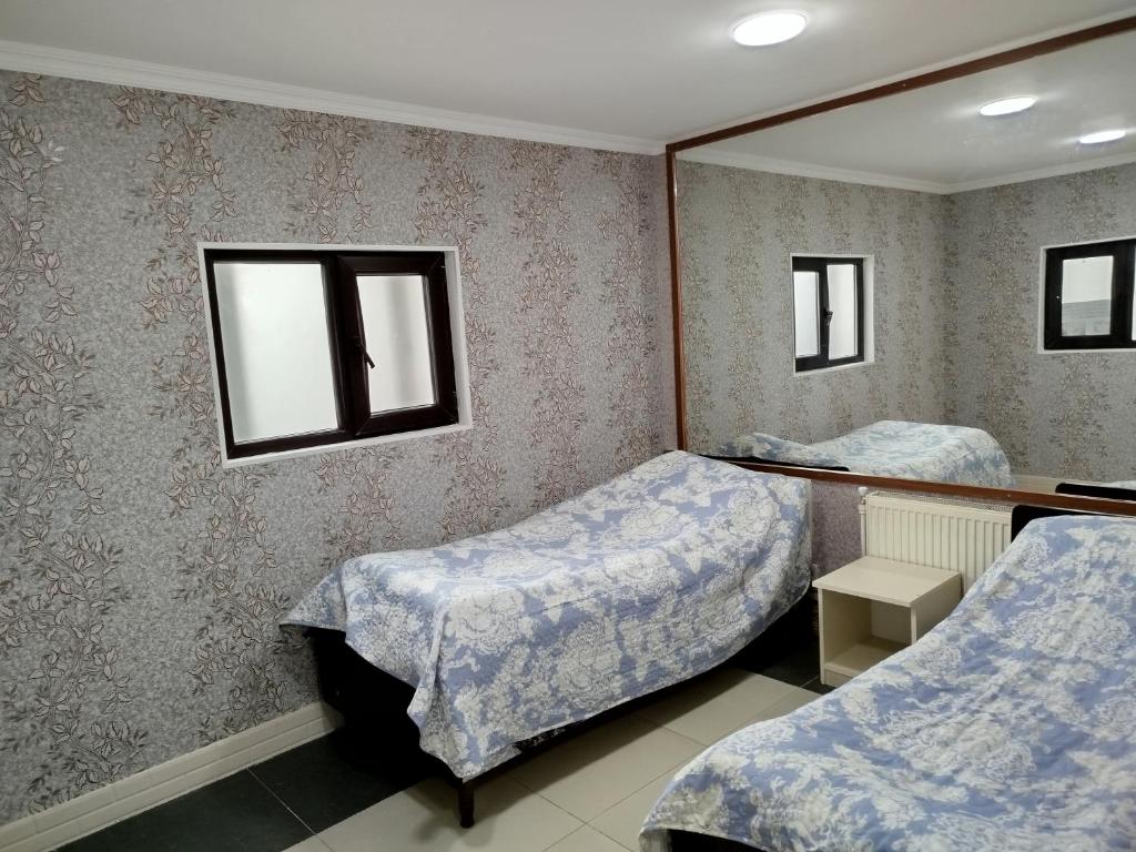 a room with two beds and a mirror at Quba ALFA-M Motel in Quba