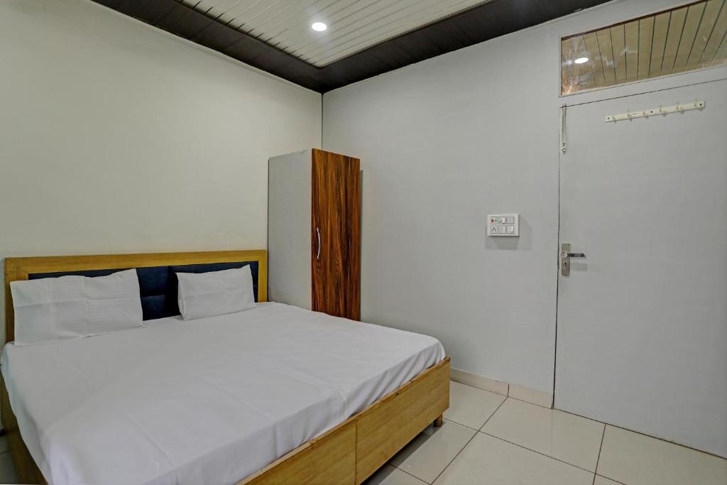 1 dormitorio con 1 cama y puerta de cristal en Super OYO Hotel Krishna Guest House & PG, en Ludhiana