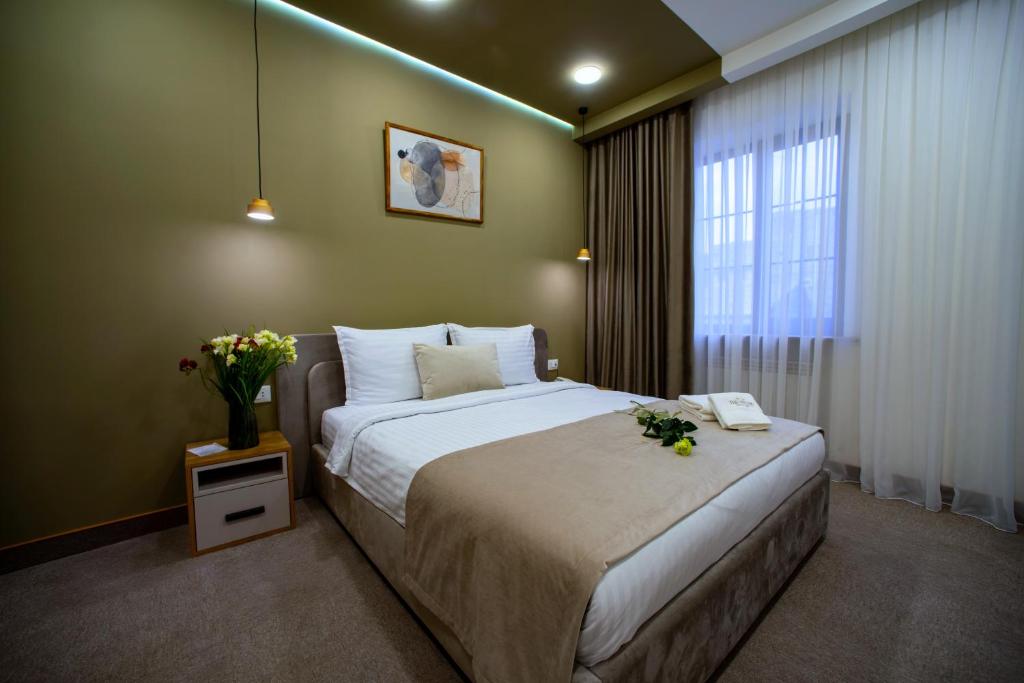 una camera da letto con un letto grande e una finestra di The House Hotel Yerevan a Yerevan