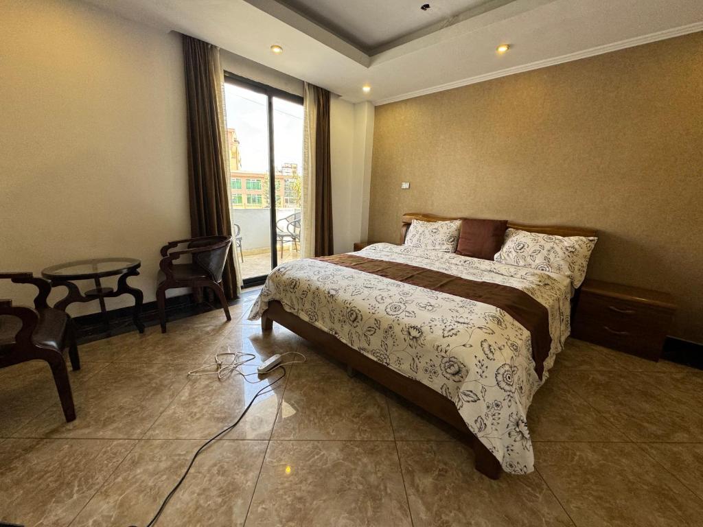 a bedroom with a bed and a table and a window at Road map Guest House in Addis Ababa