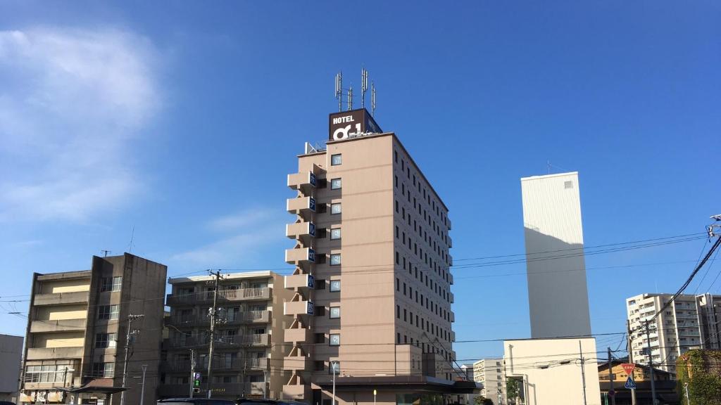 ein hohes Gebäude mit einem Schild darüber in der Unterkunft Hotel Alpha-One Ogori in Yamaguchi