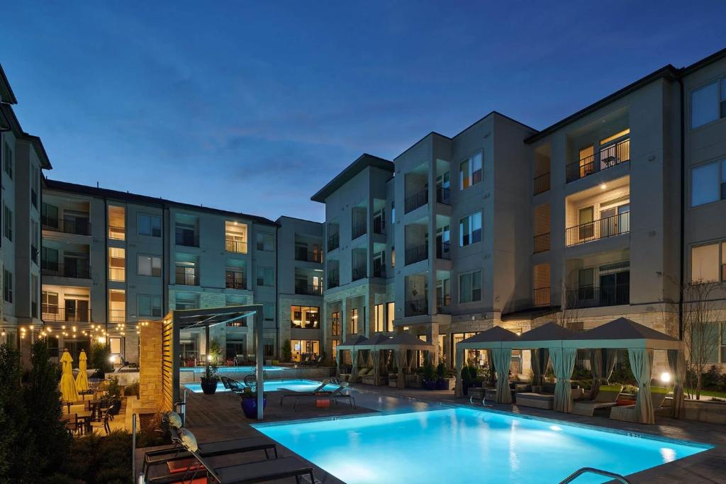 an outdoor swimming pool in front of a building at Château at Lake Austin - 10 Min Walk to Center DT in Austin