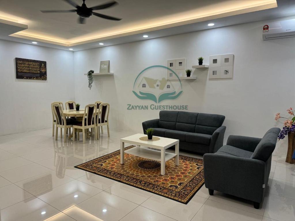 ein Wohnzimmer mit 2 Sofas und einem Tisch in der Unterkunft Zayyan Guesthouse in Kuching