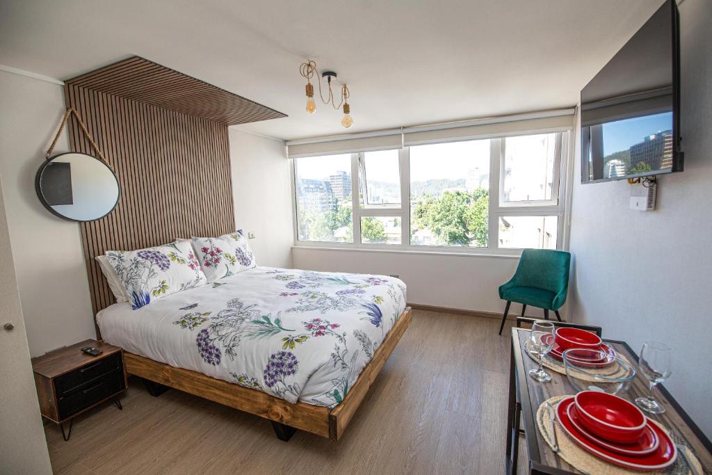 - une chambre avec un lit et une table avec des plaques de cuisson dans l'établissement Te alojo Conce, Apart Hotel, à Concepción