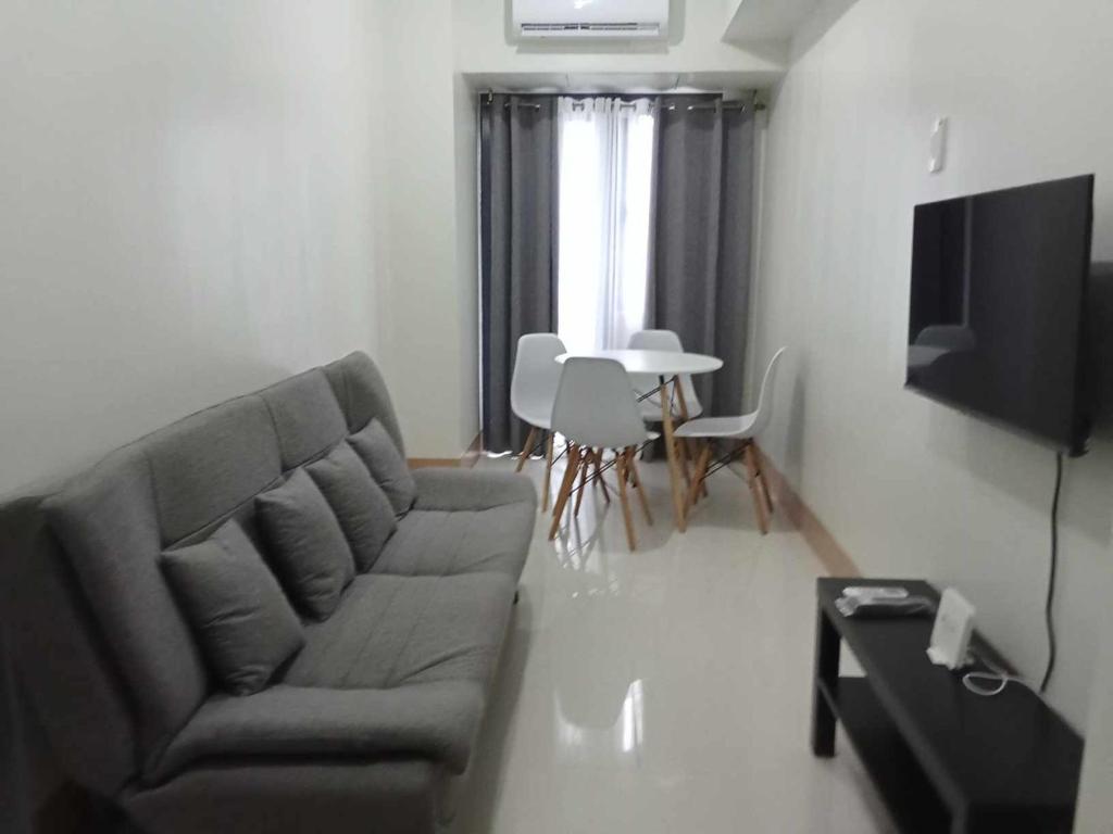uma sala de estar com um sofá e uma mesa em JM Suite at LovetoStay em Manila