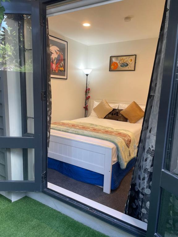 um pequeno quarto com uma cama e uma janela em Auckland CBD, Parnell Ensuite+Patio+Secluded Garage em Auckland