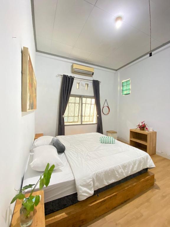 a bedroom with a bed and a window at Lorent Hostel Near Padang Beach in Padang