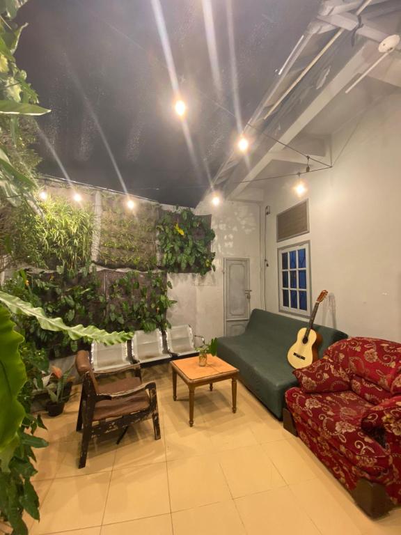 a living room with a couch and a guitar at Lorent Hostel Near Padang Beach in Padang