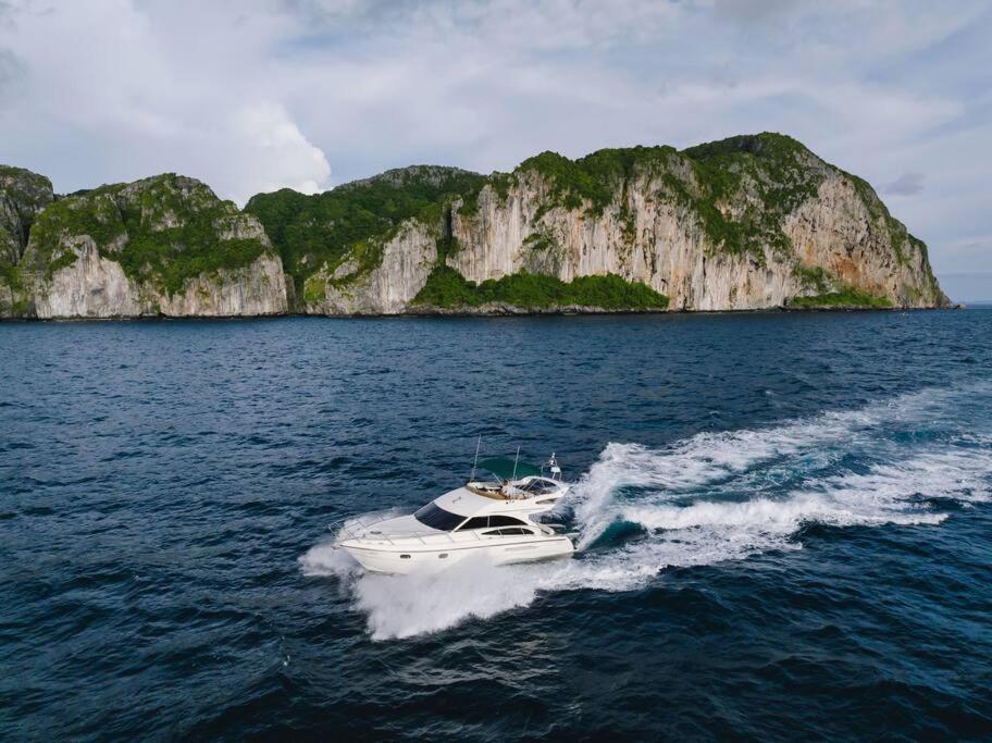 a boat in the water near a large island at Jelly Bear in Ban Bang Khu