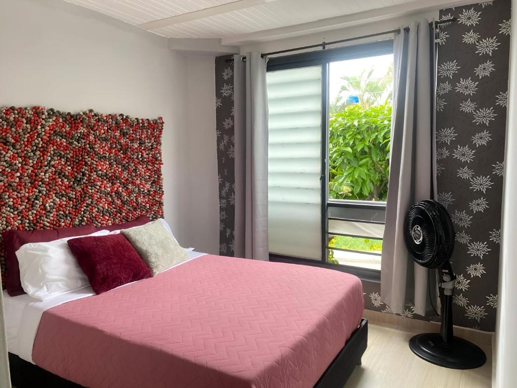 1 dormitorio con cama rosa y ventana en BORA Apto 201 Tu espacio Fuera de Casa, en Ibagué
