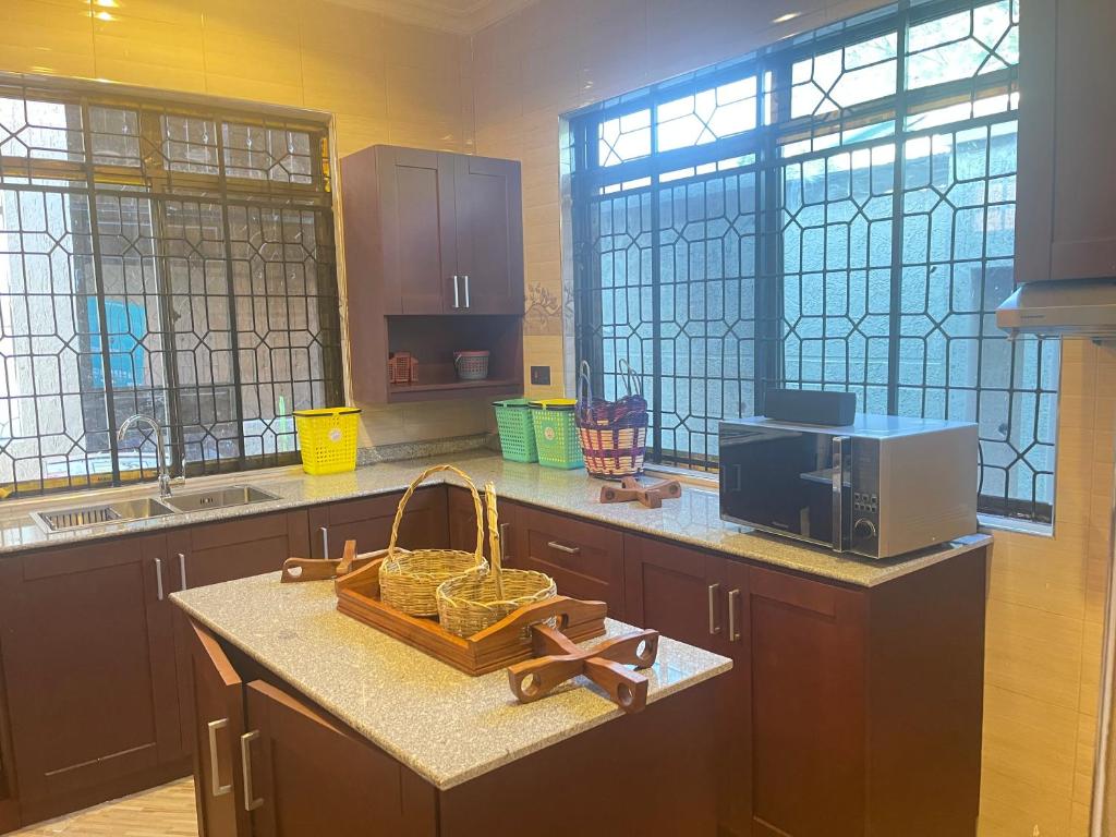 a kitchen with a counter with a basket and a microwave at Woodland Cottage in Mwanza