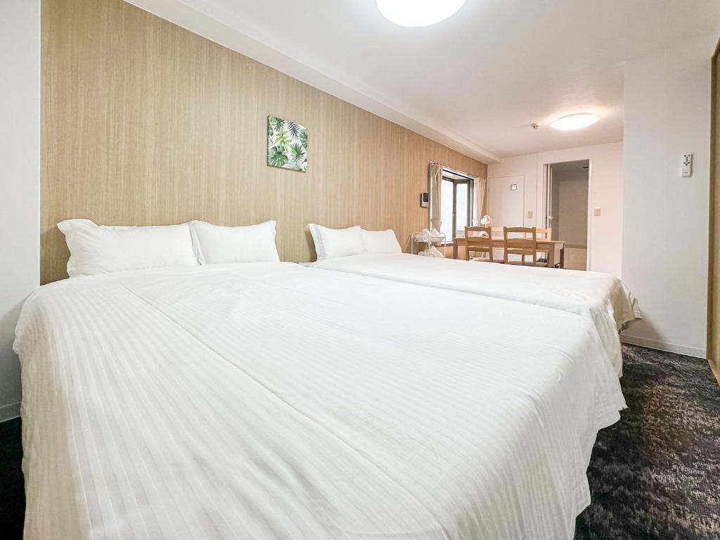 - un grand lit blanc dans une chambre d'hôtel dans l'établissement TuTuLu302, à Osaka