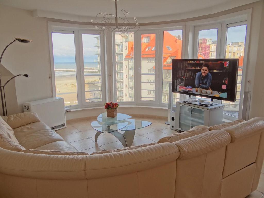 a living room with a couch and a flat screen tv at Apartment Sea View 0604 with top location in Nieuwpoort