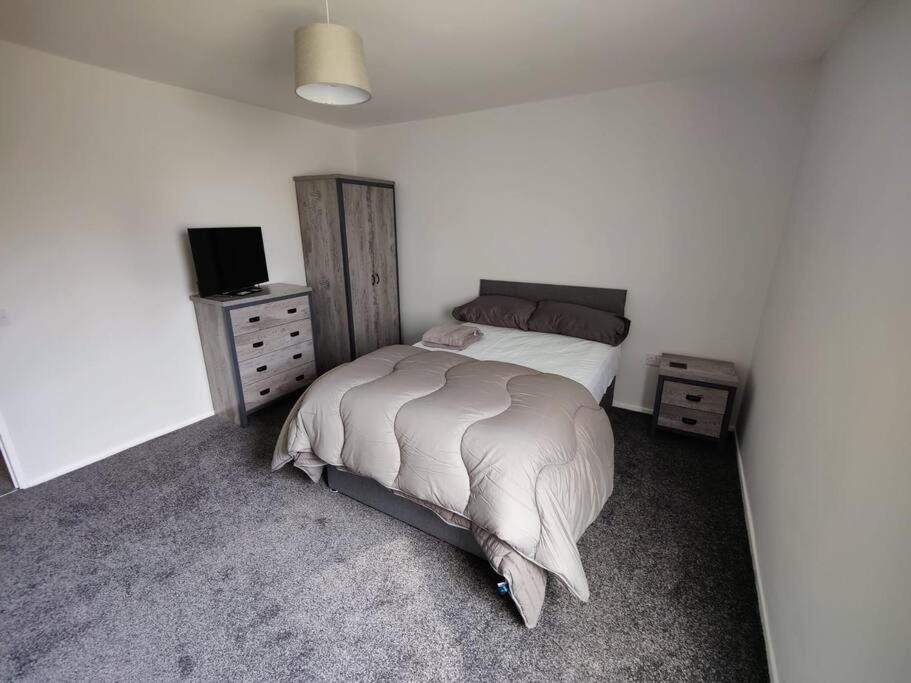 a bedroom with a bed and a television in it at Completely Renovated House with 4 Double Beds in Halton