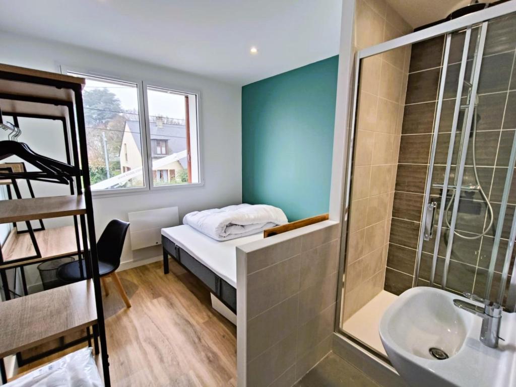 a bathroom with a bed and a shower and a sink at Chambre avec douche privative in Angers