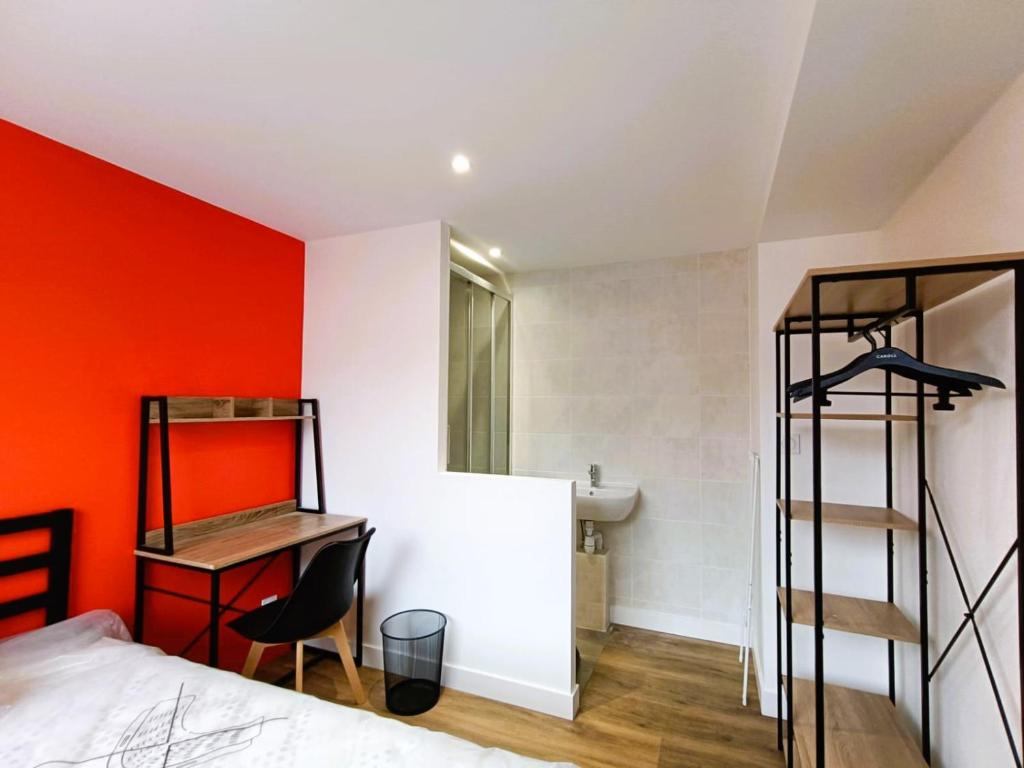 a bedroom with an orange accent wall and a bed at Chambre avec douche privative in Angers