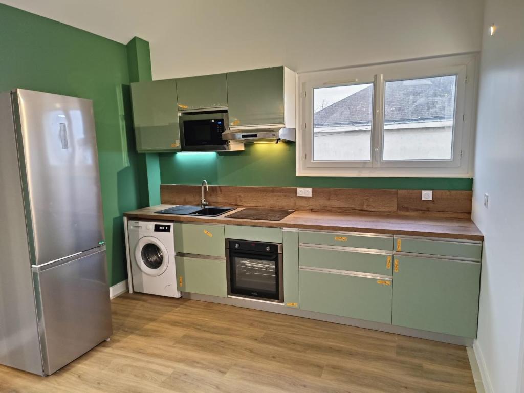 a kitchen with green cabinets and a sink and a dishwasher at Chambre avec douche privative in Angers