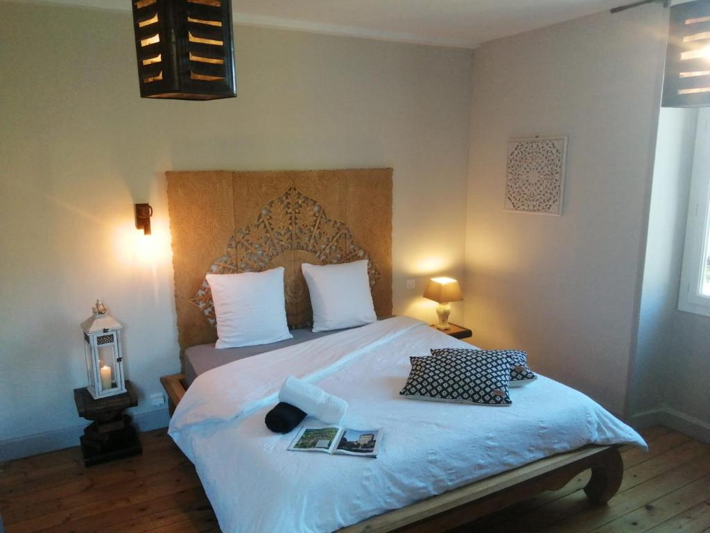 - une chambre avec un grand lit et 2 livres dans l'établissement La maison O kiwis - Chambres d'hôtes, à Saint-Denis-lès-Martel