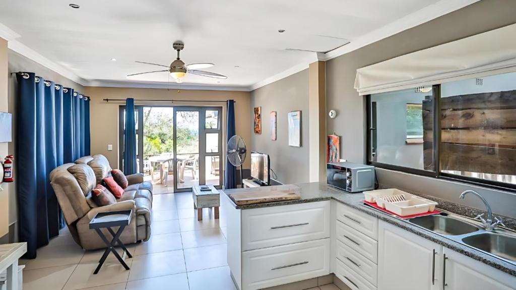 eine Küche mit einem Waschbecken und ein Wohnzimmer in der Unterkunft Zur See - 50m2 Private apartments with Braai - Self catering in Ballito
