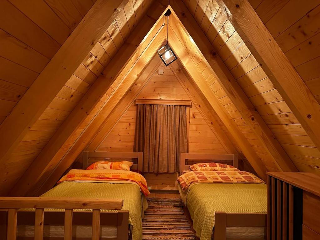 2 camas en una habitación en una cabaña de madera en Forest rest en Pluzine