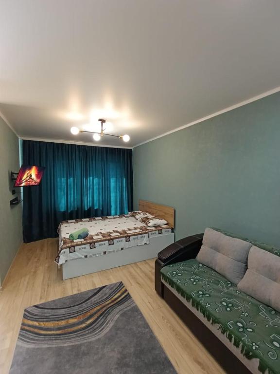 sala de estar con cama y sofá en BURATINO, en Petropavlovsk