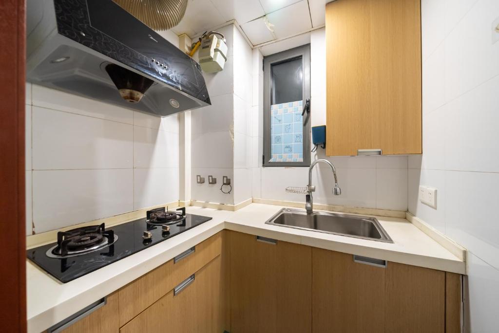una piccola cucina con lavello e fornello di Cloud Expo Apartment a Shanghai