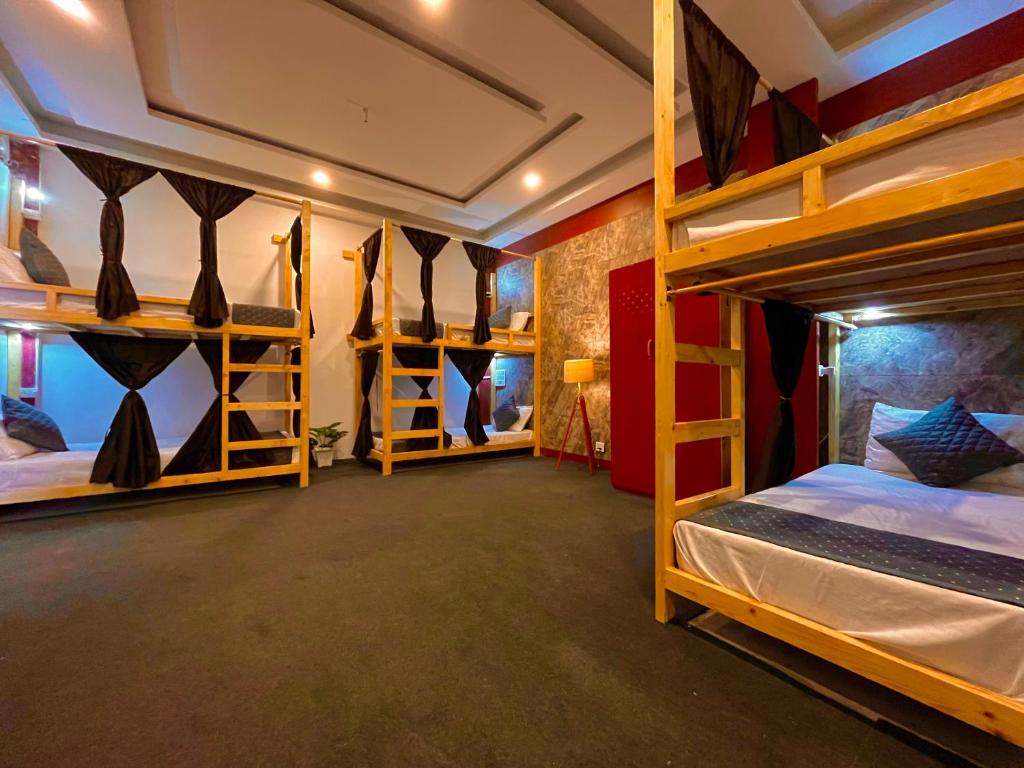 a room with two bunk beds and a closet at VISTA HOSTEL Near Mall Road Manali - with Playing Zone & Gym in Manāli