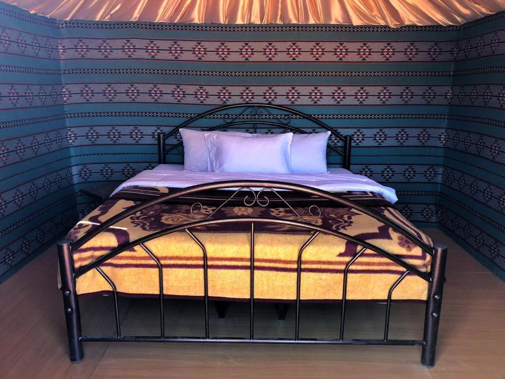 a bed in a room with a wall at Wadi Rum Backpacker Camp in Wadi Rum