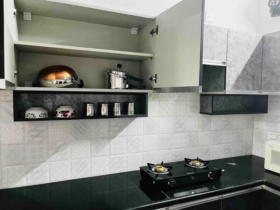 uma cozinha com uma placa de fogão e forno. em Apartment near LNT & CTC & Airport - 3F em Chennai