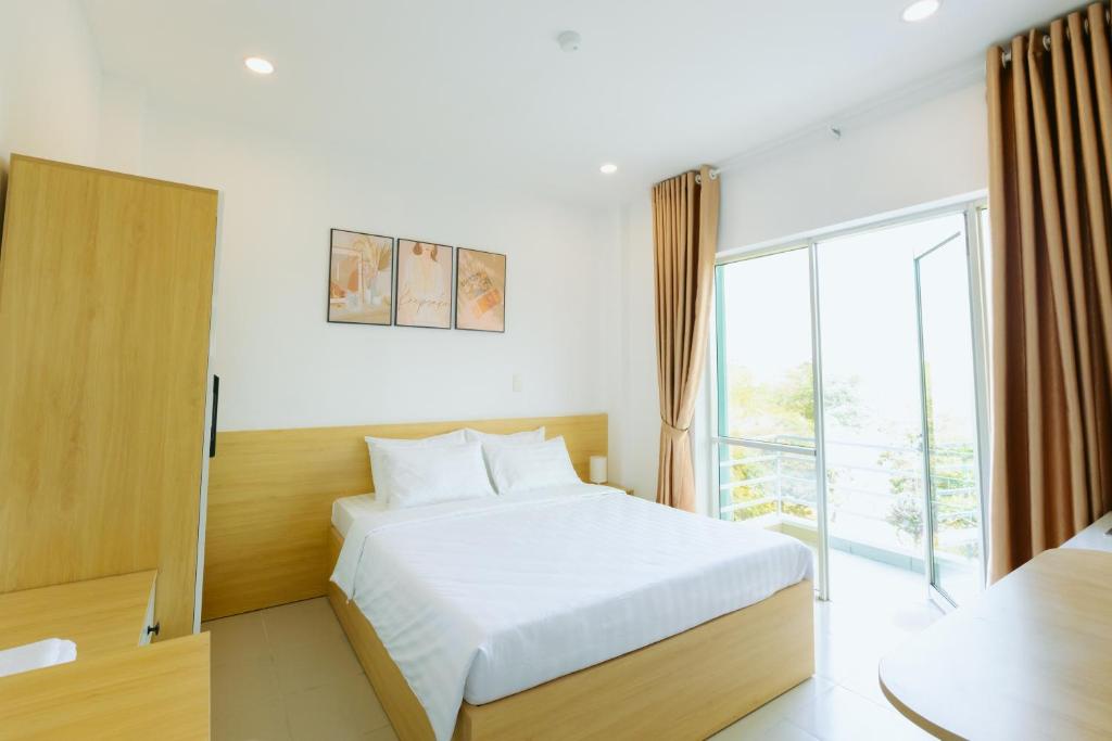 een slaapkamer met een bed en een groot raam bij BIG Hotel Sài Gòn in Ho Chi Minh-stad