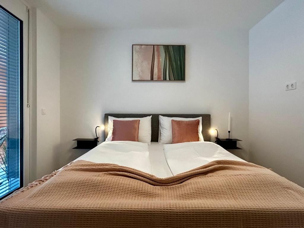 1 dormitorio con 1 cama grande y 2 lámparas en sHome Apartments Graz - Self-Check-in & free parking, en Graz