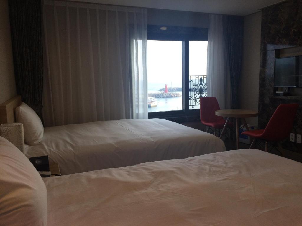 Postel nebo postele na pokoji v ubytování Dream Jeju Hotel