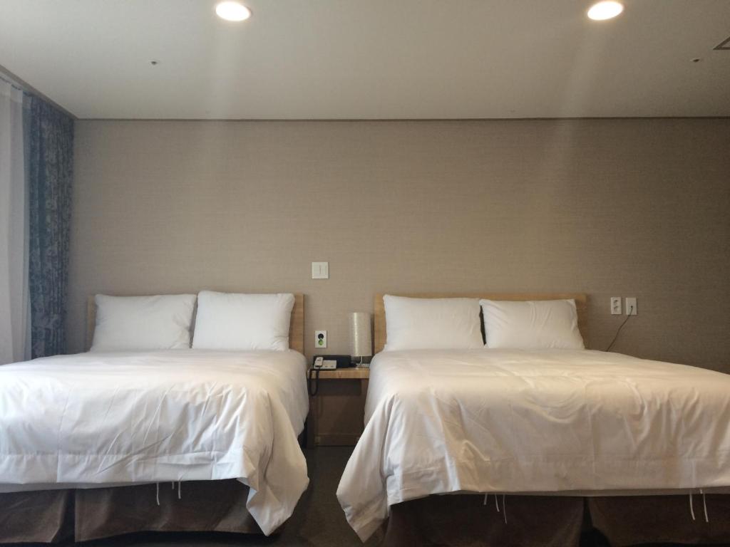 Postel nebo postele na pokoji v ubytování Dream Jeju Hotel